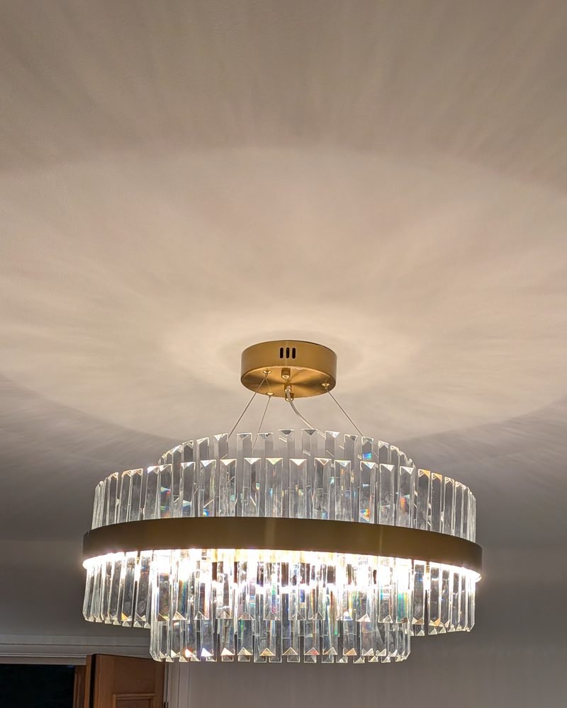 Tiered crystal chandelier with a brass band in a London hallway